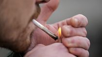A man smokes cannabis in Cologne, Germany, at a public consumption event at the start of a new law in April 2024. 