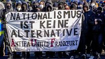 Demonstrators carry a sign reading "nationalism is no alternative" during a protest against an AfD election campaign in Neu Isenburg near Frankfurt, Germany, Saturday, Feb. 1,