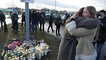 People gather at a makeshift memorial near the scene of a shooting