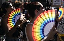People holding rainbow-colored fans gather in Buenos Aires, Argentina, Saturday, Feb. 1, 2025, during a protest against President Javier Milei’s speech at the WEF.