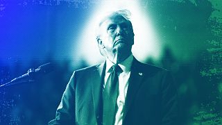 Republican presidential nominee and former President Donald Trump watches a video screen at a campaign rally in Salem, VA, November 2024