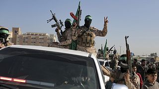 A crowd greets Islamic Jihad and Hamas fighters as they arrive for the hand-over of Ihostages to the Red Cross in the south Gaza Strip town of Khan Younis, 30 January 2025