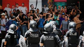 Protesters shouting harangues are guarded by riot police after a demonstration called by Argentina's Labor Union (CGT) 