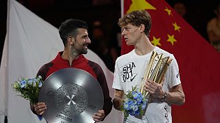 Jannik Sinner right, chats with Novak Djokovic.