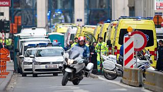 A police motorcycle rides by ambulances at a staging station near a metro after an explosion in Brussels on Tuesday, March 22, 2016.