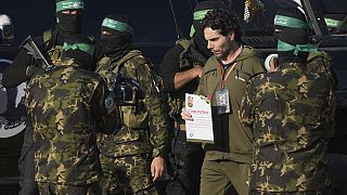 Israeli Ofer Kalderon who has been held hostage by Hamas in Gaza since October 7, 2023, walks next to Hamas fighters before being handed over to the Red Cross