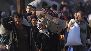 A Palestinian woman carries her belongings home in the north of the Gaza Strip, 28.01.2025