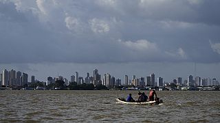 A boat sails on the bay of the Guama River with Belem, Brazil, in the background