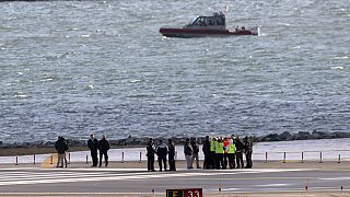 Officials gather at the end of runway 33 near the wreckage site in the Potomac River of a mid-air collision between an American Airlines jet and a Black Hawk helicopter