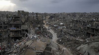 Palestinians walk in the destruction caused by the Israeli air and ground offensive in Jabaliya, Gaza Strip, Thursday, Feb. 6, 2025. 