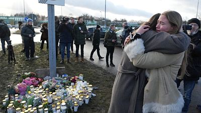 People gather at a makeshift memorial near the scene of a shooting