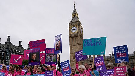 A small demonstration by people advocating assisted dying hold a protest outside the Hoses of Parliament, 2024.