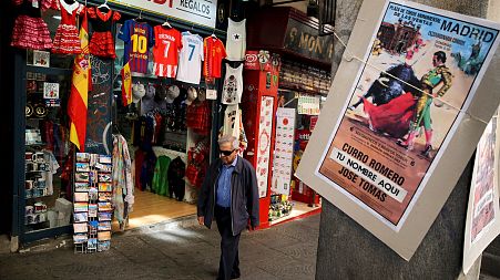File picture of a man walking past a souvenir shop in the centre of Madrid 