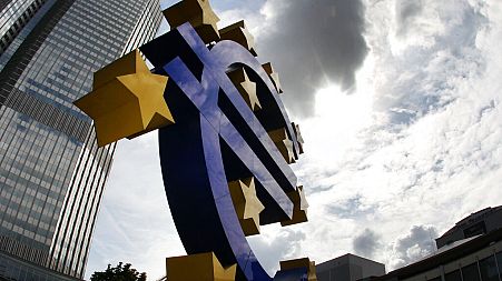 FILE - In this July 31, 2012 file photo the euro sculpture stands in front of the headquarters of the European Central Bank, ECB, in Frankfurt
