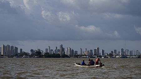 A boat sails on the bay of the Guama River with Belem, Brazil, in the background