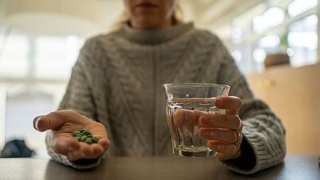 A woman prepares to take medication.