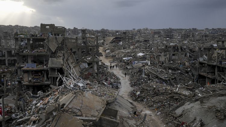 Palestinians walk in the destruction caused by the Israeli air and ground offensive in Jabaliya, Gaza Strip, Thursday, Feb. 6, 2025. 